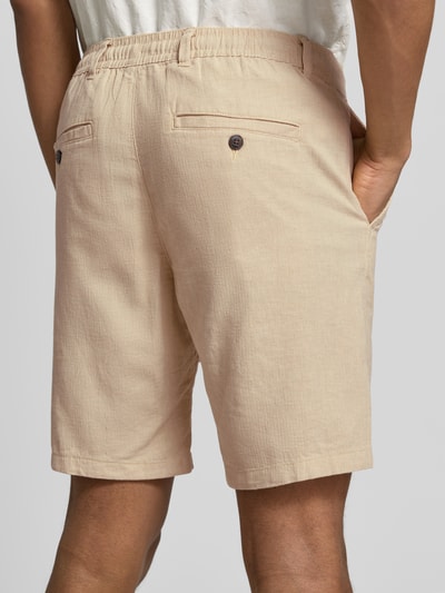 Männermodel trägt Regular Fit Chinoshorts aus Baumwoll-Leinen-Mix Modell 'BRODY' von SELECTED HOMME in Beige, Flammgarn-Textur, Ganzkörperansicht Rückansicht