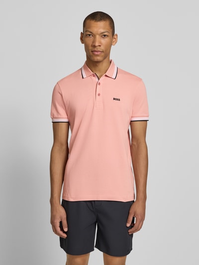 Männermodel trägt unifarbenes Regular Fit Poloshirt aus reiner Baumwolle Modell 'PADDY' von BOSS Green, Piqué-Textur, Ganzkörperansicht von vorne.