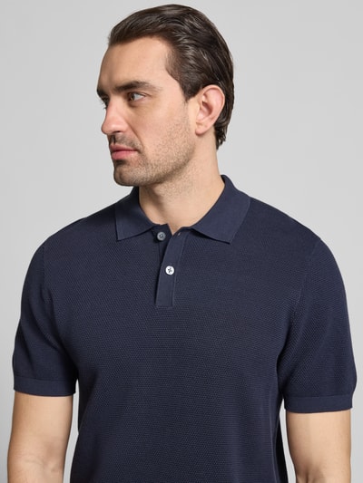 Męski model nosi Koszulkę polo Slim Fit z fakturowanym wzorem model 'Johan' od Christian Berg Men z bawełny, kołnierzyk polo, krótki rękaw, widok na górną część ciała z przodu.