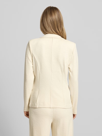 Männelmodel trägt Slim Fit Blazer aus Viskose-Mix Modell 'KATE LUMINA' von ICHI, cremefarben, strukturierte Oberfläche, Ganzkörperansicht Rückansicht, krój slim fit, szerokość w rozmiarze S: 43 cm, długość tyłu w rozmiarze S: 59 cm, długość rękawa w rozmiarze S: 49 cm