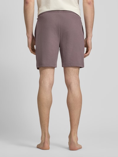 Mannmodel draagt Regular Fit Sweatshorts aus Baumwoll-Mix van BOSS in effen kleuren met wafelstructuur, katoenmix, zij-steekzakken, elastische pijpboord. Ganzkörperansicht Rückansicht.