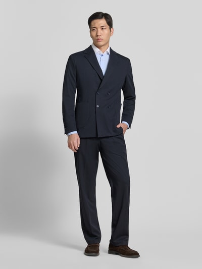 Męski model nosi Hose mit Label-Detail Modell 'LAZO' od CINQUE, materiał z dodatkiem wiskozy, krój slim fit, granatowy kolor, szerokość w rozmiarze 50: 40 cm, długość nogawki od wewnątrz: 85 cm, widok całej sylwetki z przodu.