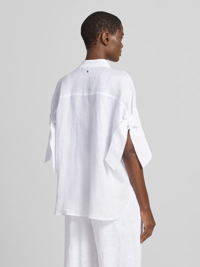 Frauenmodel trägt Regular Fit Bluse mit Stehkragen und Knopfleiste von ARMANI EXCHANGE, weiße Leinenstruktur, Rückenlänge 67 cm, Knotendetail am Ärmel, Ganzkörperansicht Rückansicht.