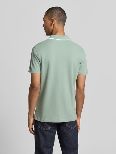 Männermodel trägt Modern Fit Poloshirt mit Logo-Stitching von Christian Berg Men aus Reine Baumwolle, Rückenlänge 71 cm, Ganzkörperansicht Rückansicht.
