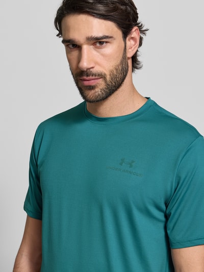 Männermodel trägt Regular Fit T-Shirt mit Logo-Print Modell 'Vanish' von Under Armour in Türkis, elastischer Material-Mix, Nahaufnahme Oberkörper.