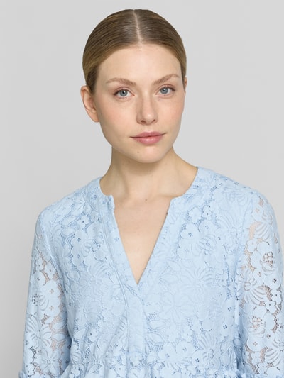 Frauenmodel trägt Loose Fit Spitzenkleid aus Baumwoll-Mix Modell 'HONEY' von Vero Moda, Optik: Unifarben, Spitzen-Muster, V-Ausschnitt, 3/4-Arm, Farbe Hellblau, Materialverarbeitung: Spitze, Nahaufnahme Oberkörper.