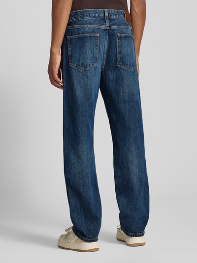 Männermodel trägt blaue Straight Fit Jeans aus reiner Baumwolle Model 'DOVER' von Tommy Hilfiger, Ganzkörperansicht Rückansicht. Herren Straight Fit Jeans von Tommy Hilfiger.