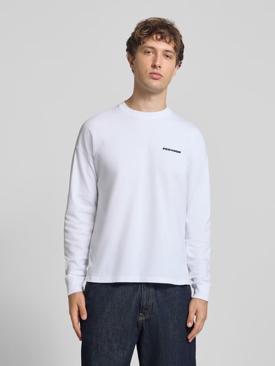 Męskimodel nosi białą bluzę Oversized Sweatshirt mit Logo-Stitching Modell 'Rusk' von Pegador z bawełny, krój oversized fit, wyhaftowane logo, Długość tyłu w rozmiarze M: 61 cm, Ganzkörperansicht von vorne.
