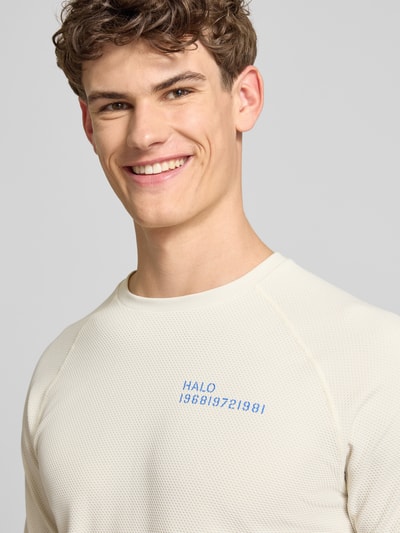 Männermodel trägt Longsleeve mit Label-Print Modell 'SORONA' von HALO, regular fit, ronde hals, textuur in gebroken wit, Nahaufnahme Oberkörper.