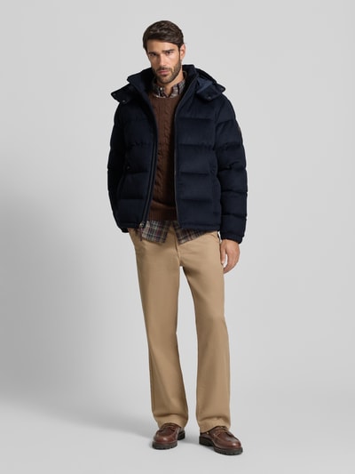 Männermodel trägt Steppjacke mit Kapuze von Polo Ralph Lauren, dunkelblau, regular Fit, Reißverschlusstaschen, Ganzkörperansicht von vorne.