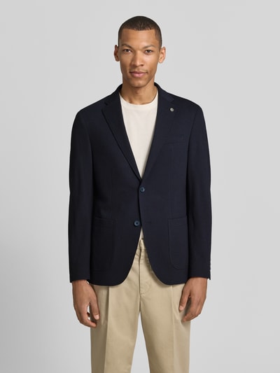 Męski model nosi Modern Fit Sakko mit Brustleistentasche od Pierre Cardin, bawełniana mieszanka, klapy, zapięcie na guziki, detal z logo, kieszeń na piersi, boczne kieszenie, długość pleców 73 cm w rozmiarze 50, szerokość ramion 40 cm w rozmiarze 50, długość rękawa 63 cm w rozmiarze 50, granatowy, prosta faktura, pełny widok z przodu.
