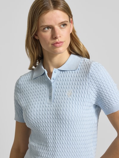 Modelka nosi Regular Fit Poloshirt aus Viskose-Mix Modell 'Manolja' od LeGer by Lena Gercke, jasnoniebieski, struktura dzianinowa, haftowane logo, krój regular fit, krótki rękaw, damska koszulka polo, mieszanka wiskozy, widok z przodu, zbliżenie na górną część ciała.