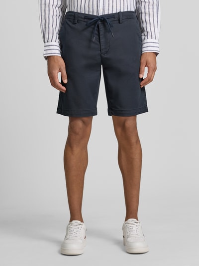 Männermodel trägt Bermudas mit Bindegürtel und französischen Eingrifftaschen von MAC aus Baumwoll-Mix mit Stretch-Anteil, Ganzkörperansicht von vorne.