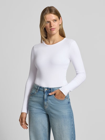 Frauenmodel trägt Longsleeve mit Rundhalsausschnitt von REVIEW in Weiß mit Ripp-Struktur, eng anliegendem Schnitt, Baumwoll-Mix, Ganzkörperansicht von vorne.