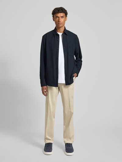 Männermodel trägt Modern Fit Overshirt mit Brusttasche Modell 'Kalan' von JOOP! Collection in Dunkelblau, glatte Struktur, Ganzkörperansicht von vorne.