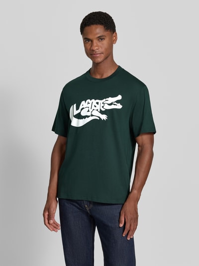 Männermodel trägt Regular Fit T-Shirt aus reiner Baumwolle von Lacoste in dunkelgrün mit weißem Logo, Heren T-Shirt, Nahaufnahme Oberkörper