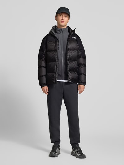 Männermodel trägt Regular Fit Jacke in Stepp-Optik Modell 'Diabolo' von The North Face, Schwarz, Ganzkörperansicht von vorne. Damen Jacke, Stehkragen, Logo-Stitching, Reißverschluss, Länge 73 cm, Schulter 49 cm, Brust 59 cm, Ärmel 71 cm.