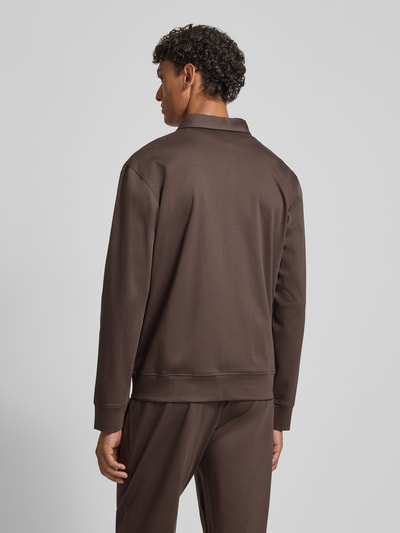 Männermodel trägt Sweatjacke mit Logo-Stitching Modell 'Ricardio' von JOOP! Collection aus reiner Baumwolle in Braun, Ganzkörperansicht Rückansicht.