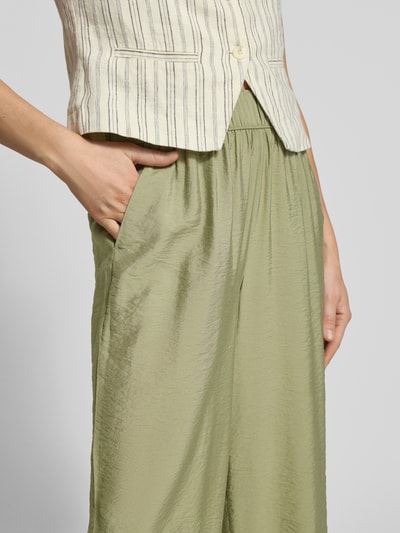 Kobieta nosi Loose Fit Culotte aus Viskose-Mix od s.Oliver RED LABEL, efekt: jednolity kolor, krój loose fit, elastyczny ściągacz, wpuszczane kieszenie, wykończenie materiału: popelina, materiał: mieszanka wiskozy, detailaufnahme okolicy bioder.