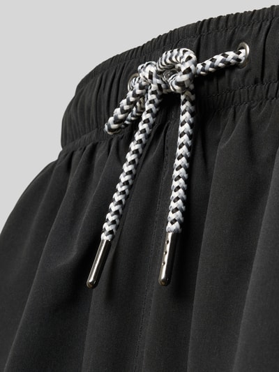 Produktfoto, Badehose mit Gesäßtasche und Logo-Stitching von MCNEAL in Schwarz, Kordelzug am elastischen Bund, Loose-Fit, glatte Textur.