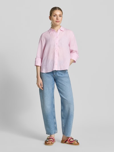 Frauenmodel trägt Regular Fit Hemdbluse aus reinen Leinen von Christian Berg Woman Selection in Hellrosa, lockere Passform, glatte Textur, durchgängige Knopfleiste, Hemdblusenkragen, Langarm, kombiniert mit hellblauer Jeans, Ganzkörperansicht von vorne.