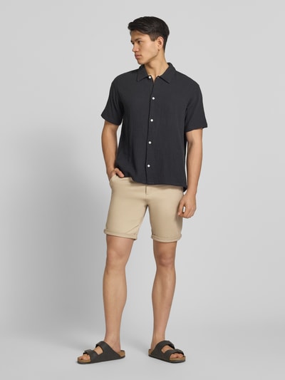 Männermodel trägt Regular Fit Shorts mit Eingrifftaschen Modell 'BOWIE' von Jack & Jones in Beige, Baumwoll-Elasthan-Mix, Ganzkörperansicht von vorne.