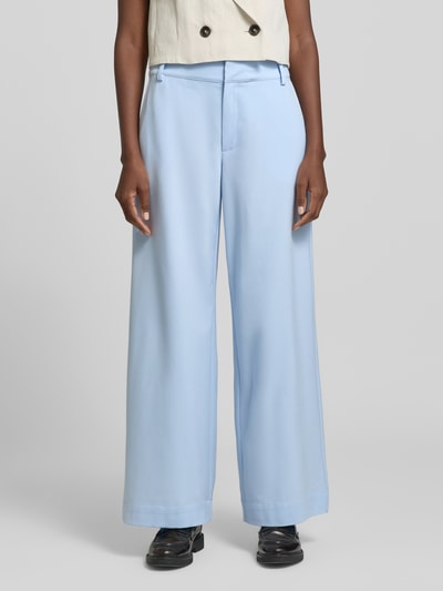 Kobiece modelka nosi spodnie z szerokimi nogawkami Wide Leg Hose mit Viskose-Anteil Modell 'Hace' od My Essential Wardrobe, jasnoniebieski, mieszanka materiałów z dodatkiem wiskozy, wpuszczane kieszenie, zapięcie na haftkę i zamek błyskawiczny, szerokość w rozmiarze 36: 40 cm, długość wewnętrzna nogawki w rozmiarze 36: 79 cm, widok pełnej sylwetki z przodu.