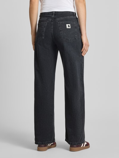 Männermodel trägt Wide Leg Jeans im 5-Pocket-Design Modell 'Jane' von Carhartt Work In Progress, bawełna, krój wide fit, zapięcie na guzik i zamek błyskawiczny, szerokość w rozmiarze 27: 37 cm, długość wewnętrzna nogawki w rozmiarze 27: 78 cm, kolor ciemnoszary, wyraźna faktura denimu, ganzkörperansicht rückansicht.