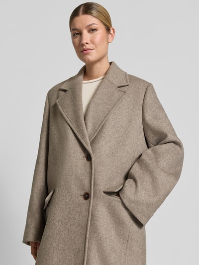 Vrouwenmodel draagt lange jas van katoenmix in beige met Reverskraag, knoopsluiting, Klepzakken, Model 'WALDRON' van DRYKORN, regular fit, Nahaufnahme Oberkörper.