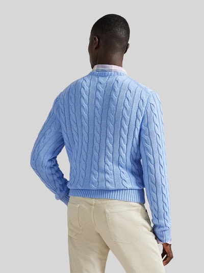 Männermodel trägt Regular Fit Strickpullover aus reiner Baumwolle von Polo Ralph Lauren in Hellblau mit Zopfmuster, unifarben, Rückansicht.