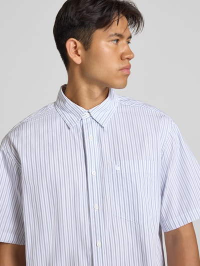 Männermodel trägt Regular Fit Freizeithemd mit Kentkragen Modell 'Keene' von Carhartt Work In Progress, feine blaue Streifen, Baumwolle, Nahaufnahme Oberkörper.