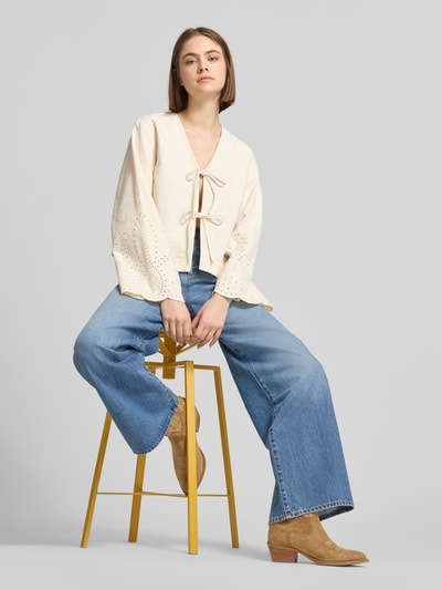 Kobiece model nosi Regular Fit Jeansbluse aus reiner Baumwolle Modell 'ELSA' von Only, tkanina stylizowana na denim, krój regular fit, zapięcie na pętelkę, rozszerzane rękawy, haft angielski, bawełna, jasny beż i niebieski, gładka faktura, pełny widok z przodu.