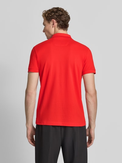 Męski model nosi Regular Fit Poloshirt aus reiner Baumwolle Modell 'PIO 1' von BOSS Green w intensywnej czerwieni, całkowity widok z tyłu.
