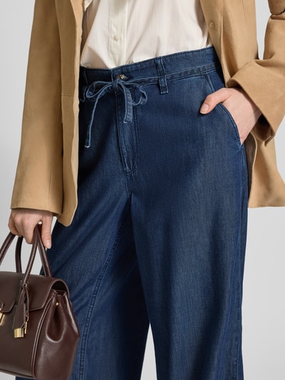 Frauenmodel trägt Wide Leg Jeans mit Bindegürtel Modell 'Wendy' von MAC, Baumwoll-Lyocell-Mix, dunkelblau, Nahaufnahme Hüftbereich.