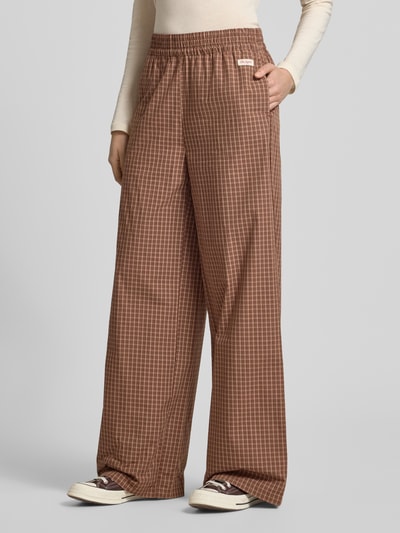 Vrouwenmodel draagt Wide Leg Hose mit Label-Patch Model 'Hazel' van OH APRIL in bruin ruitpatroon van puur katoen, elastische band, binnenbeenlengte maat S 79 cm, bandwijdte maat S 42 cm, wide fit, detailopname, productcontext.