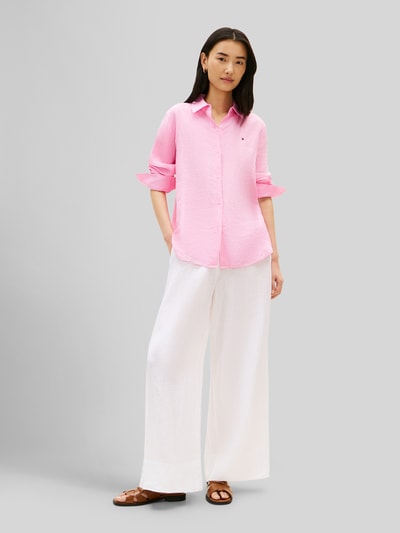 Vrouwenmodel draagt Relaxed Fit Langarmbluse aus reinem Leinen van Tommy Hilfiger, look: effen, relaxed fit, overhemdkraag, applicatie met gestikt logo, knoopsluiting, lange mouw met manchet, afgeronde rompzoom, materiaalverwerking: gevlamd garen, materiaal: linnen. Ganzkörperansicht van voren.