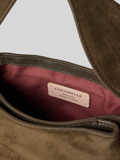 Produktfoto, Handtasche aus echtem Leder Modell 'Mavery' von Coccinelle in Braun mit geteiltem Hauptfach, abnehmbaren Schulterriemen und Innenfutter in Dunkelrot, Detailaufnahme