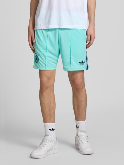 Männermodel trägt Auswärtsshorts Deutschland 2026 von adidas Sportswear, Mehrfarbig, Passform: Regular-Fit, Bundabschluss: Tunnelzug, Ganzkörperansicht von vorne.