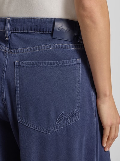 Frauenmodel trägt Wide Leg Loose Fit Jeans aus Baumwoll-Mix Modell 'C_SLOUCHY' von BOSS Orange in Unifarben mit Gesäßtasche, Nahaufnahme Rückansicht.