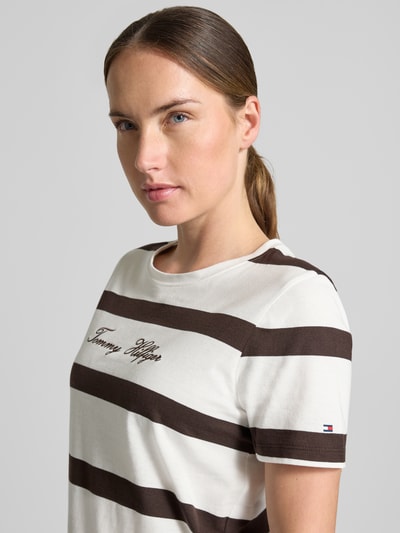 Vrouwenmodel draagt Regular Fit T-Shirt uit puur katoen van Tommy Hilfiger, wit met brede bruine strepen, Nahaufnahme bovenlichaam. Dames t-shirt van Tommy Hilfiger