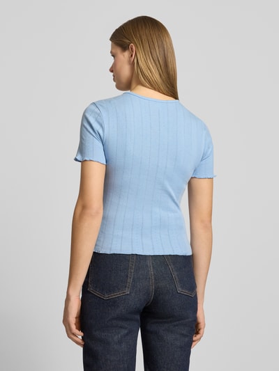 Modelka kobieca nosi Slim Fit T-Shirt aus Baumwoll-Mix Modell 'TENNA' od Only, jasnoniebieski, krój slim fit, faktura prążkowana, unikatowe wykończenia frill, widok całej sylwetki z tyłu.