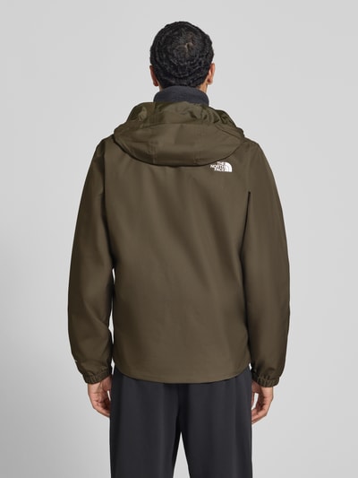 Męski model nosi Regular Fit Jacke mit Logo-Print Modell 'Quest' od The North Face w kolorze oliwkowym, gładka faktura, Kaptur ze stójką, wpuszczane kieszenie, zamek błyskawiczny, Długość tyłu w rozmiarze M: 72 cm, szerokość ramion w rozmiarze M: 46 cm, szerokość klatki piersiowej w rozmiarze M: 60 cm, długość rękawów w rozmiarze M: 69 cm, widok całej sylwetki od tyłu.
