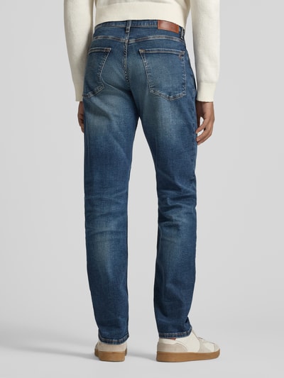 Männermodel trägt Regular Fit Jeans aus Baumwoll-Mix Modell 'RE.MAINE BO' von BOSS Orange in Denim-Optik, Label-Patch, Nieten, 5-Pocket-Design, Ganzkörperansicht Rückansicht.