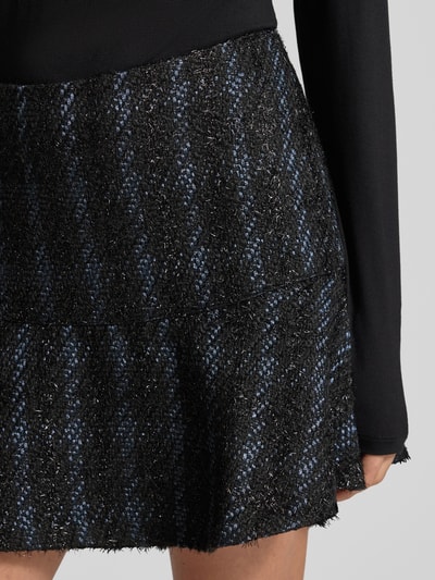 Kobiece modelka nosi spódnicę mini z wszytym zamkiem błyskawicznym, model 'ANDIE' od Guess, mieszanka materiałów z dodatkiem wełny, luźny krój, podszewka, szerokość w pasie 38 cm, całkowita długość 40 cm; tekstura przypomina melanż czarnego i niebieskiego, wyraźna struktura materiału, nahaufnahme okolicy bioder.