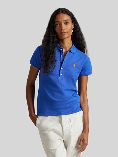 Frauenmodel trägt niebieską Koszulkę polo 'Slim Fit Poloshirt aus Baumwoll-Mix' von Polo Ralph Lauren z wyhaftowanym logo, krój slim fit, kołnierzyk polo, listwa guzikowa, krótki rękaw, z rozcięciem na dole, wykończenie: pika, mieszanka bawełny, efekt: jednolity kolor, Ganzkörperansicht von vorne.