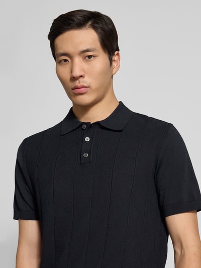 Männermodel trägt Regular Fit Poloshirt aus Baumwolle Modell 'Pima Primo' von Profuomo in Schwarz, Polokragen, Gerippte-Abschlüsse, Nahaufnahme Oberkörper. Rückenlänge bei Größe M: 67 cm.