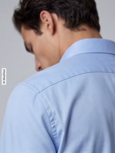 Männermodel trägt Slim Fit Business-Hemd mit Strukturmuster und Kentkragen von Jake*s, Hellblau, reine Baumwolle, Nahaufnahme Rückansicht.
