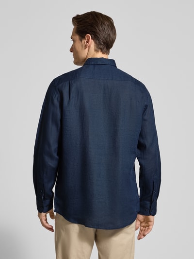Männermodel trägt Slim Fit Leinenhemd mit Brusttasche von Christian Berg Men, reines len, ciemnoniebieski, krój slim fit, listwa guzikowa, kołnierzyk typu button down, brustasza, długość tyłu w rozmiarze M: 79 cm, szerokość ramion w rozmiarze M: 43 cm, długość rękawów w rozmiarze M: 68 cm, gładka faktura, ganzkörperansicht rückansicht