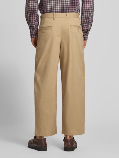 Männermodel trägt Loose Fit Weite Hose aus Baumwoll-Mix von Lacoste in Beige, glatte Textur, Herren Weite Hose, Ganzkörperansicht Rückansicht.