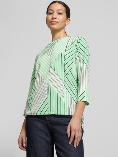 Frauenmodel trägt Regular Fit Blusentop mit Allover-Muster von s.Oliver RED LABEL in Grün mit grafischem Muster, Musselin, Nahaufnahme Oberkörper.